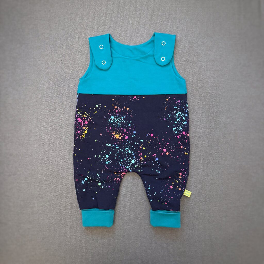 Smaragdgrüner und blauer Strampler für Babys mit bunten Farbsprenkeln von Bauchpiraten